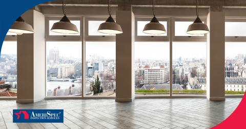 Modern office space with large windows showing a cityscape view.