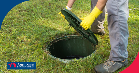 Inspector wearing gloves opens a green septic tank lid in a grassy yard.