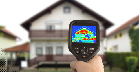 Thermal imaging camera displaying heat signature of a house exterior during inspection.