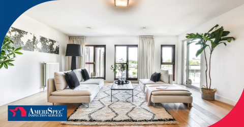 Modern living room with white sofas, a patterned rug, and large windows showing a city view.