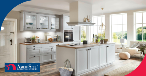 Bright modern kitchen with gray cabinets, central island, and large windows overlooking greenery.