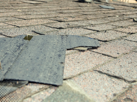Damaged shingles and flashing on a roof.